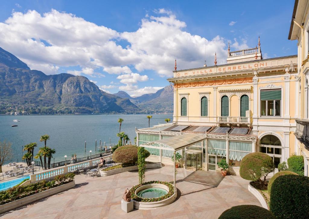 een gebouw met uitzicht op het water en de bergen bij Grand Hotel Villa Serbelloni - 150 Years of Grandeur in Bellagio