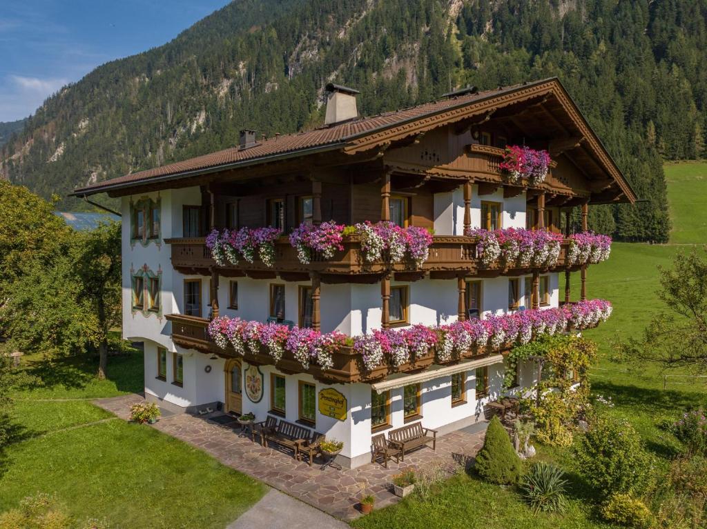 un bâtiment avec des fleurs sur le côté dans l'établissement Appartements Penzinghof, à Mayrhofen