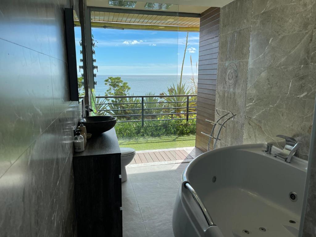 a bathroom with a tub and a view of the ocean at Paraíso sobre el Mar Torremolinos Santa Clara in Torremolinos