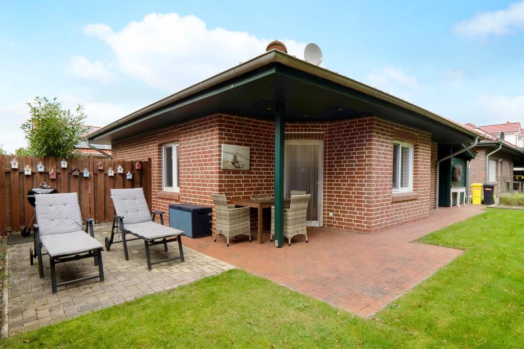 a pavilion with chairs and a table in a yard at Ferienhaus Nordlicht in Geeste
