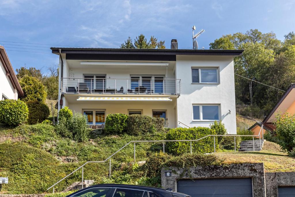 a house on a hill with a car parked in front at Fewo Stempel in Küssaberg