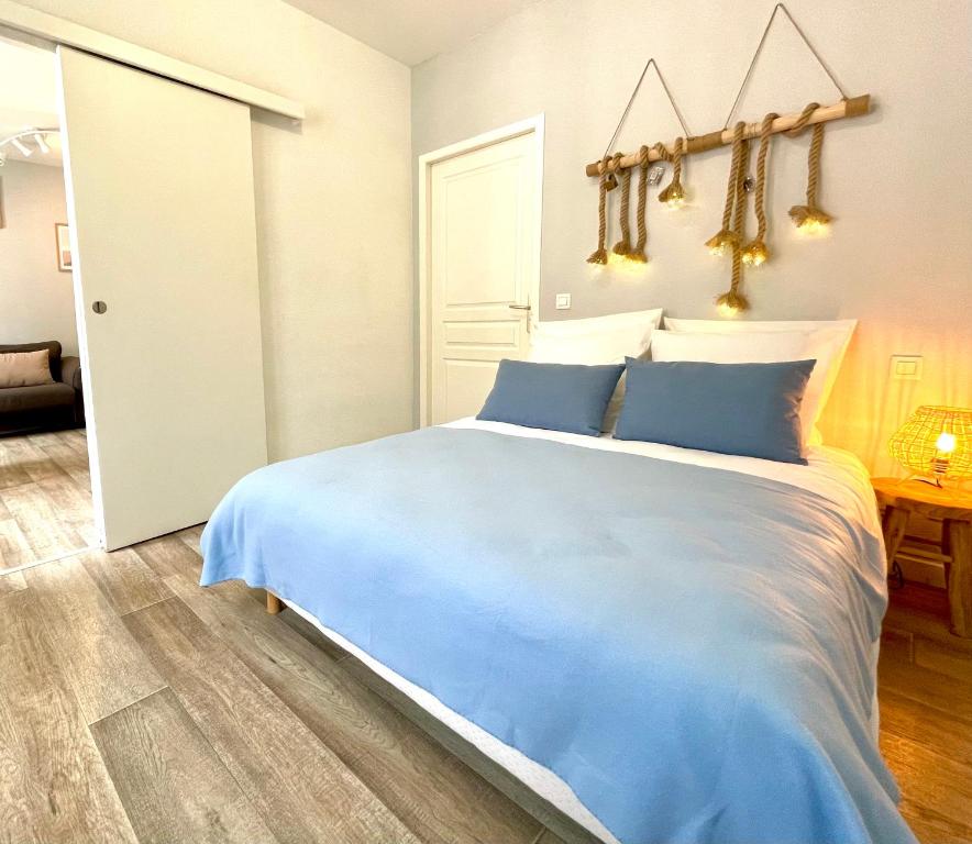 1 dormitorio con 1 cama grande con almohadas azules en L’azur - Centre ville & Lac en Nantua