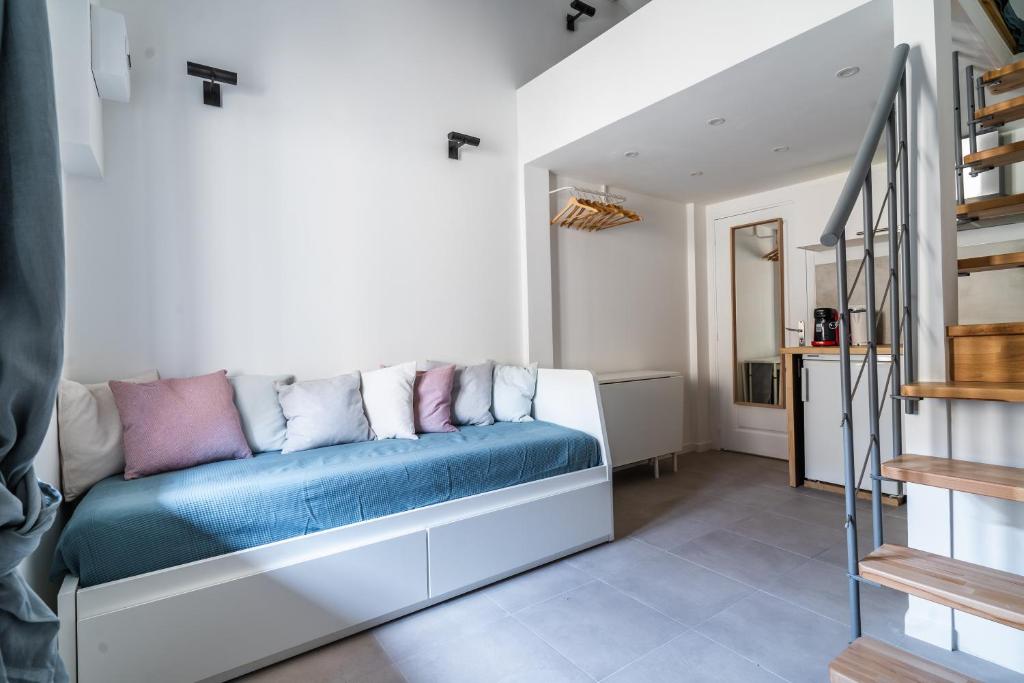 a living room with a blue couch and stairs at Bonsai Flat in Beausoleil in Beausoleil