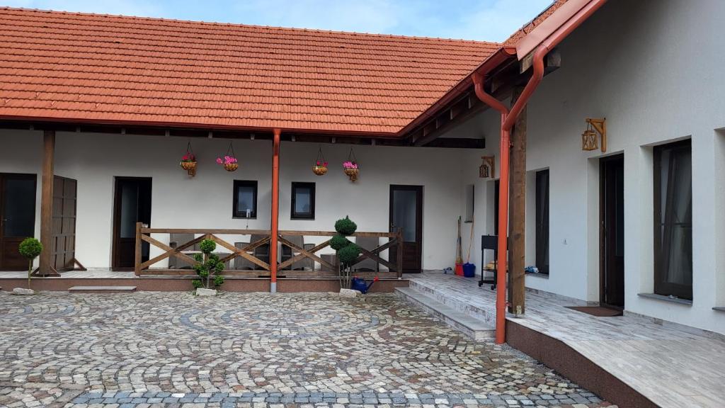 un edificio con techo rojo y patio en PENSIUNEA CASTELANA, en Racoşu de Jos