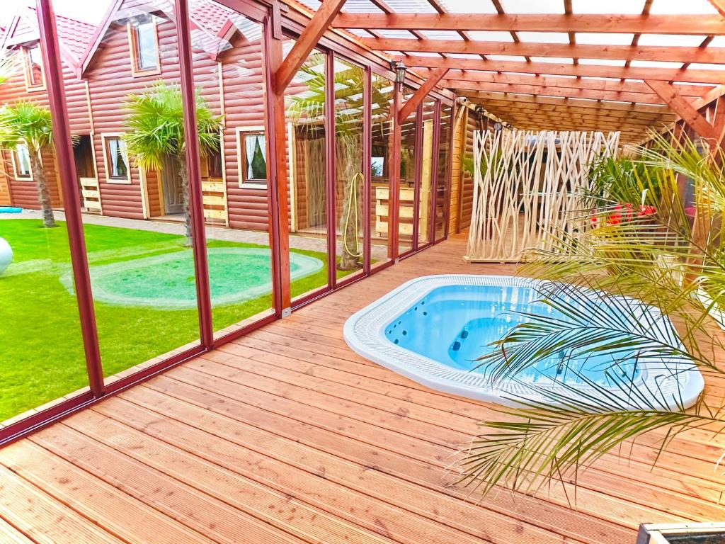 a patio with a hot tub on a wooden deck at Morze Domków Wellness & Spa in Dziwnówek