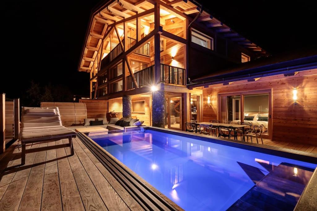 a house with a swimming pool at night at Chalet Béla Vya 5 étoiles luxe Ski & Spa in Bourg-Saint-Maurice