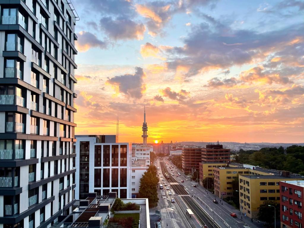 widok na miasto z wieżą telewizyjną o zachodzie słońca w obiekcie The Dawn Towers Apartment Žižkov w Pradze