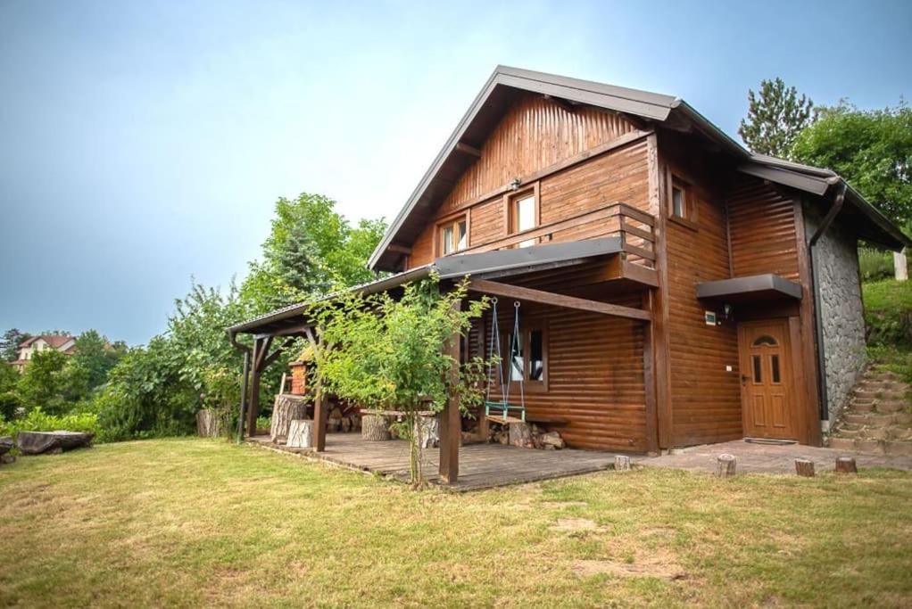 une grande maison en bois avec une cour en face de celle-ci dans l'établissement Le'Klet Holiday House, à Donji Kraj