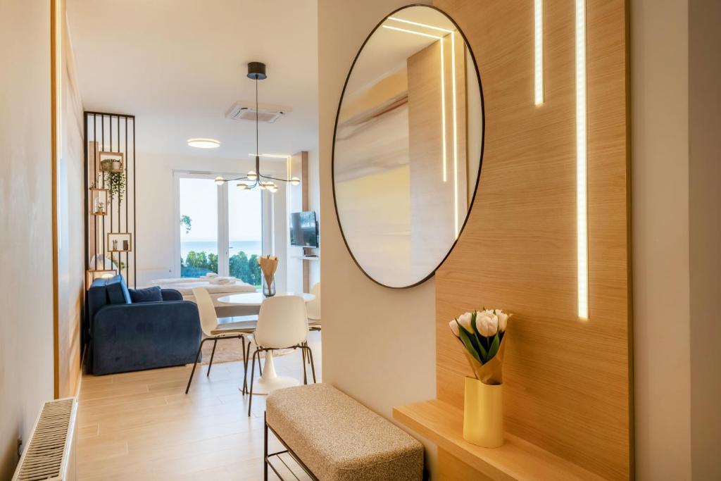 a living room with a mirror on the wall at MyFlat Club 218 Garden Wellness Apartments in Siófok