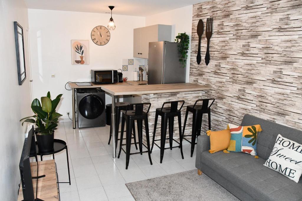 - une cuisine et un salon avec un comptoir et des tabourets dans l'établissement Appartement 32 m2 intra muros - WIFI - Netflix - Bureau, à Avignon