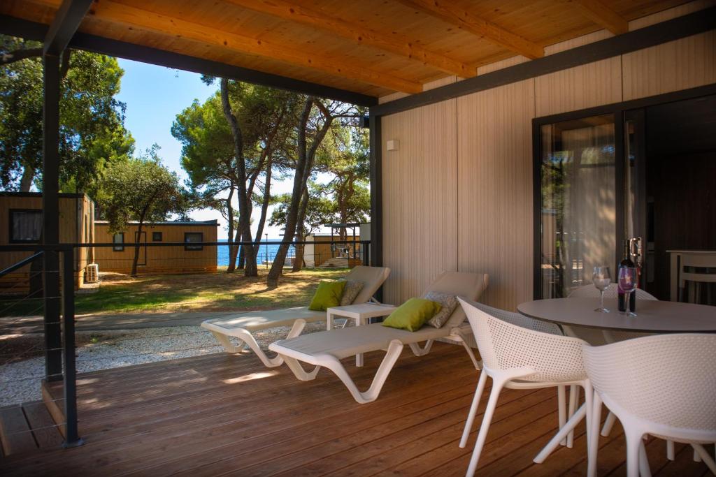 a patio with chairs and a table and a table and chairs at Arena Stoja Camping Homes in Pula