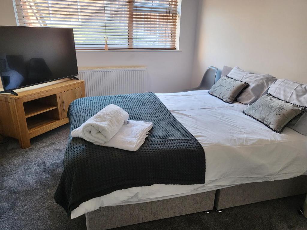 a bedroom with a bed and a flat screen tv at THE NEST in Nottingham
