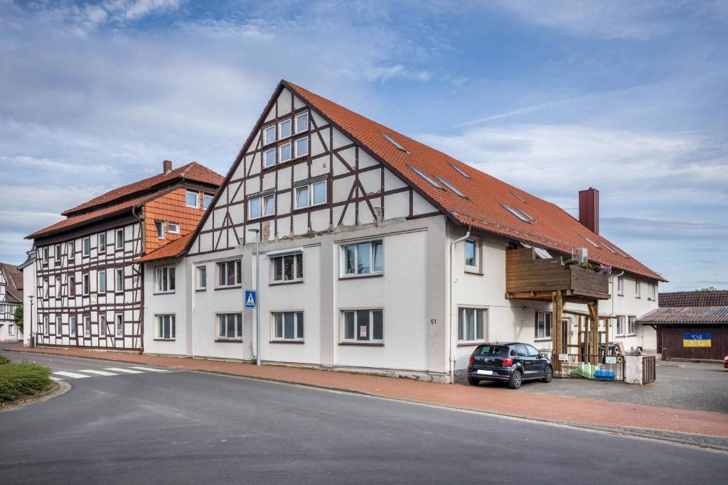 un gran edificio blanco con techo marrón en Ferienwohnung Knopf en Hardegsen
