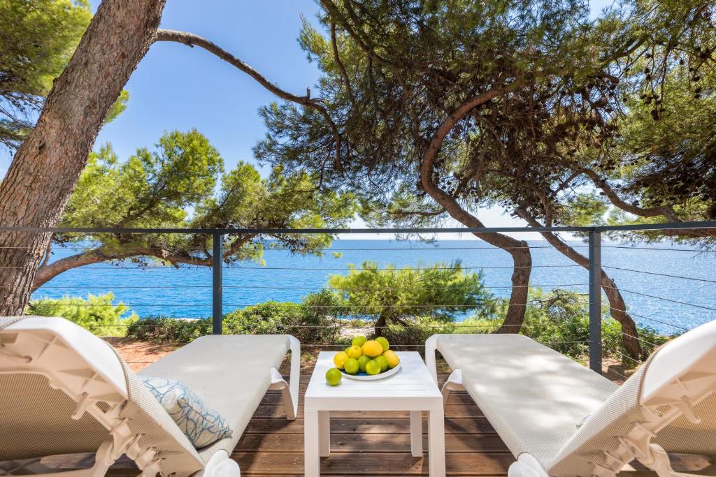 eine Terrasse mit Stühlen und einem Tisch mit einer Obstschale in der Unterkunft Arena Stoja Camping Homes in Pula