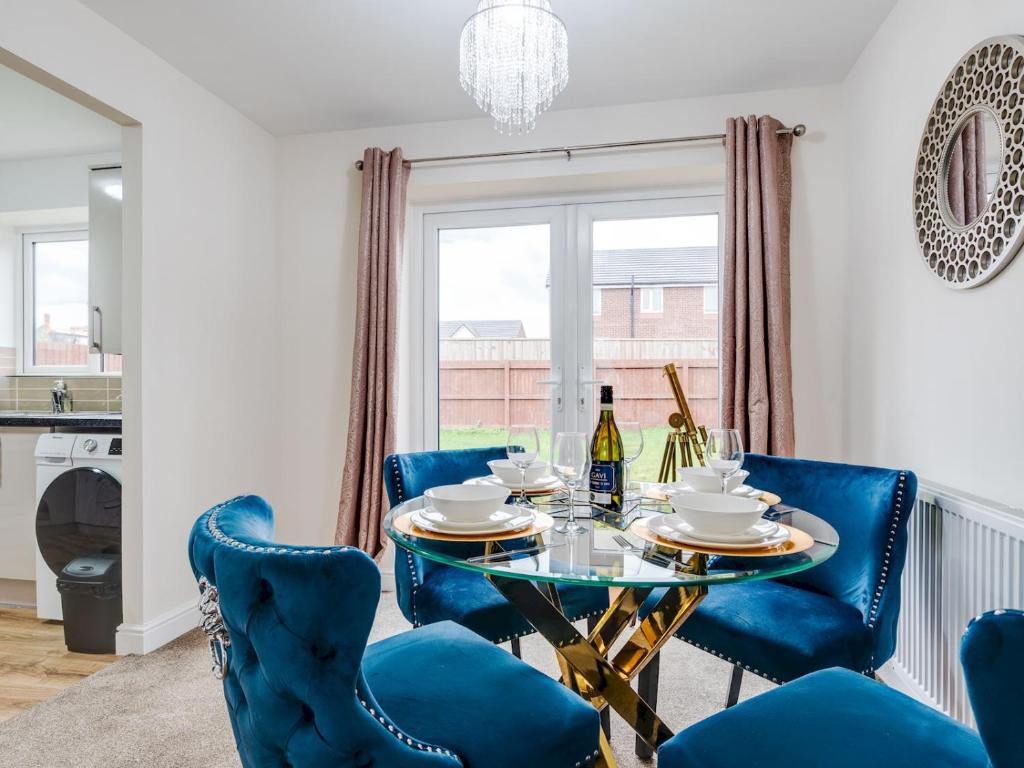 a dining room with a table and blue chairs at Pass the Keys Modern and Cozy Kirkby Retreat Parking Sleeps 5 in Knowsley