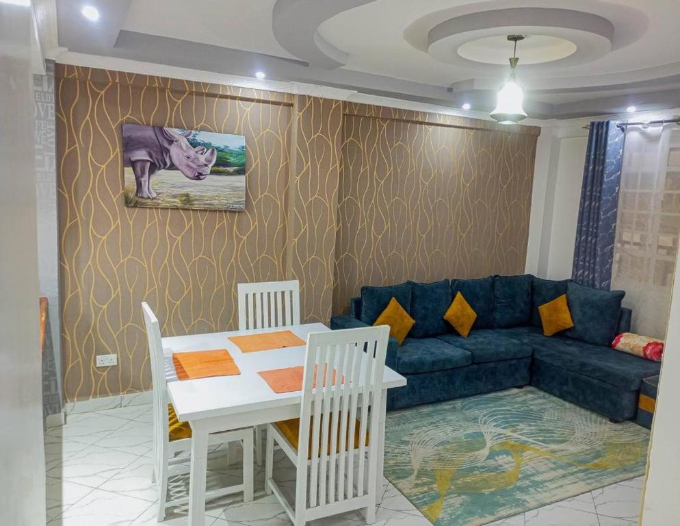 a living room with a blue couch and a table at Blèu Mustard Two Bedroom in Nanyuki