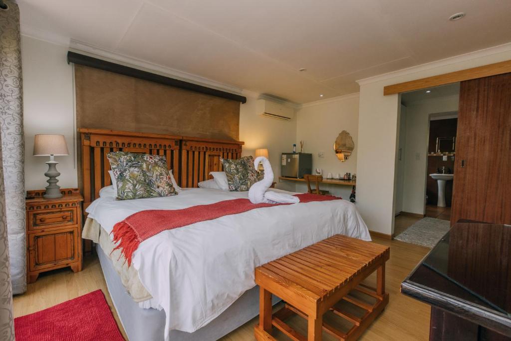 a bedroom with a large bed with a swan on it at Beetleloop Guest House in Nelspruit