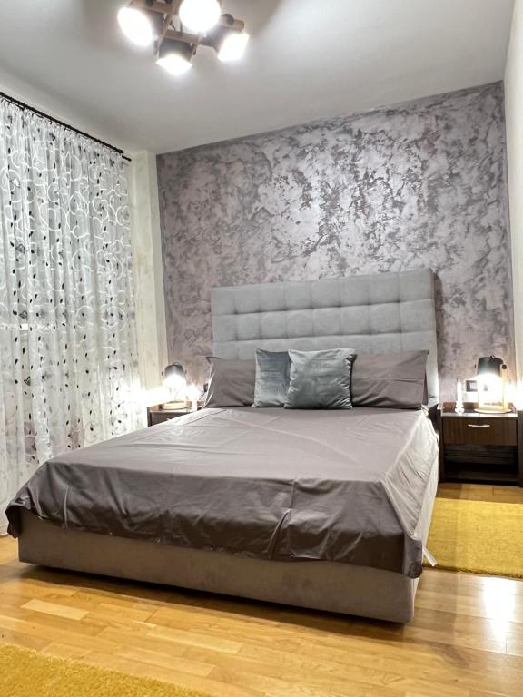 a bedroom with a large bed with a floral wallpaper at The Ring Apartament in Timişoara