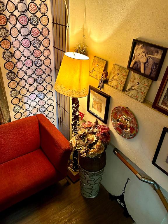 a living room with a red chair and a lamp at Taipei Triple Tiger Inn in Taipei