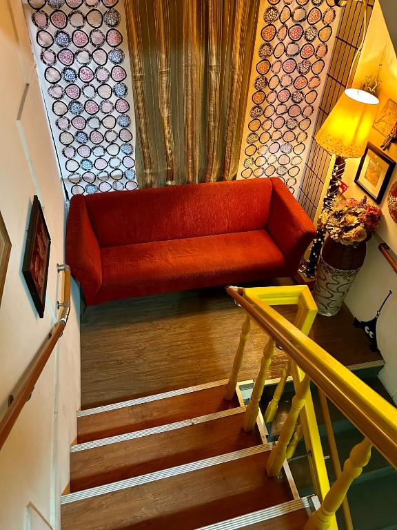 a red couch sitting on top of a staircase at Taipei Triple Tiger Inn in Taipei