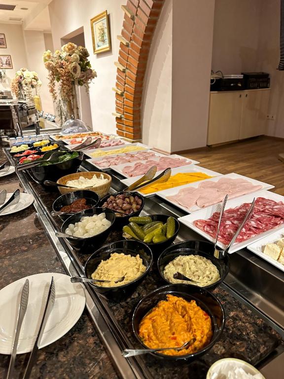 a buffet with many different types of food on a table at Caro Hotel in Bucharest