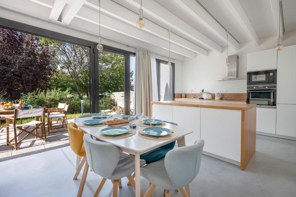 une cuisine et une salle à manger avec une table et des chaises dans l'établissement Séjour apaisant pour 6 au Pouliguen, au Pouliguen