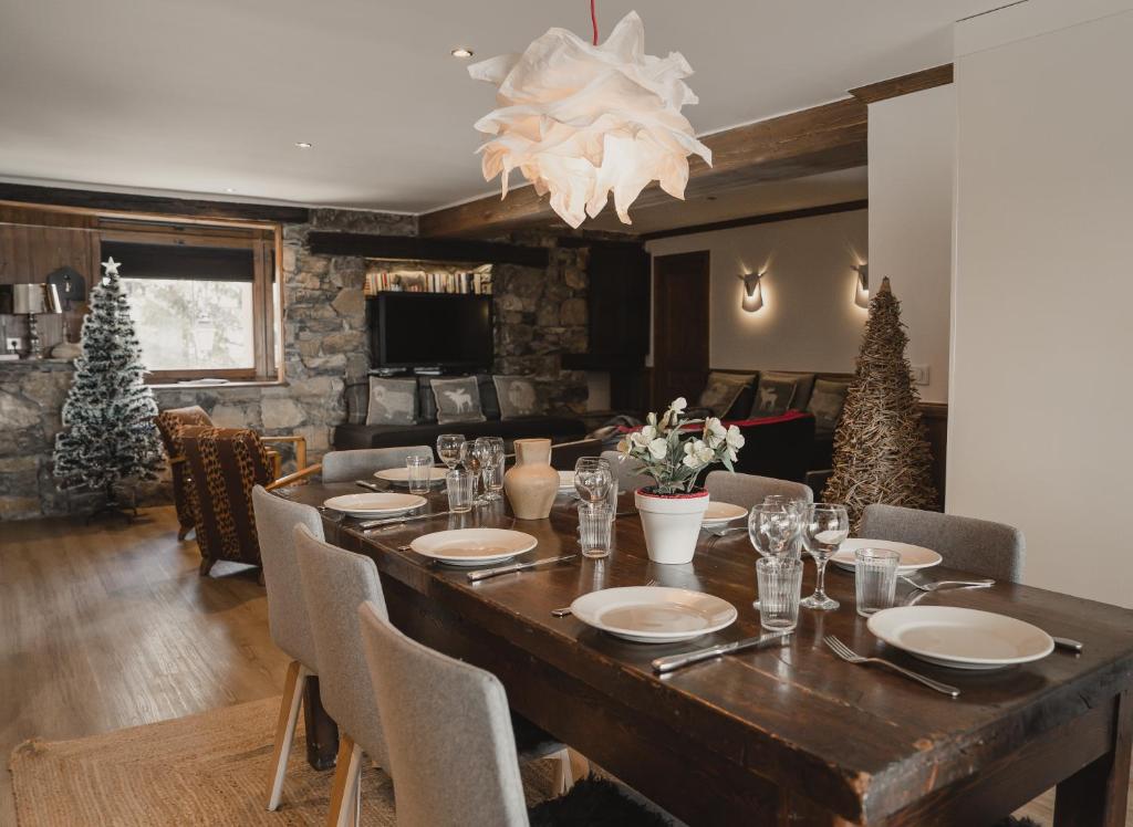 a dining room with a large wooden table and christmas trees at Hôtel Le Samovar in Val dʼIsère