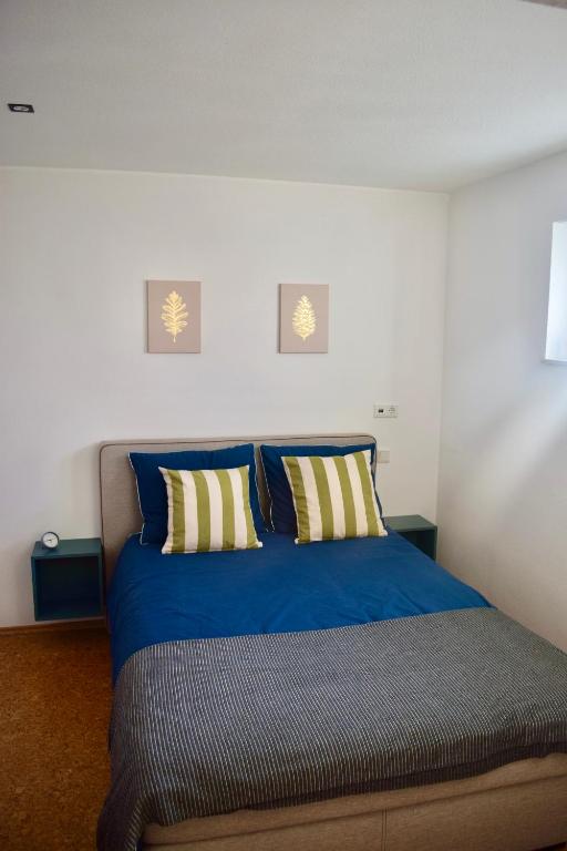a bedroom with a blue bed with two pillows at Bed and Bike Rheine in Rheine