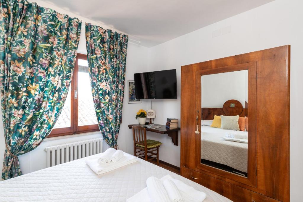 - une chambre avec 2 lits et un miroir dans l'établissement Ca'Spadolino, à Spello