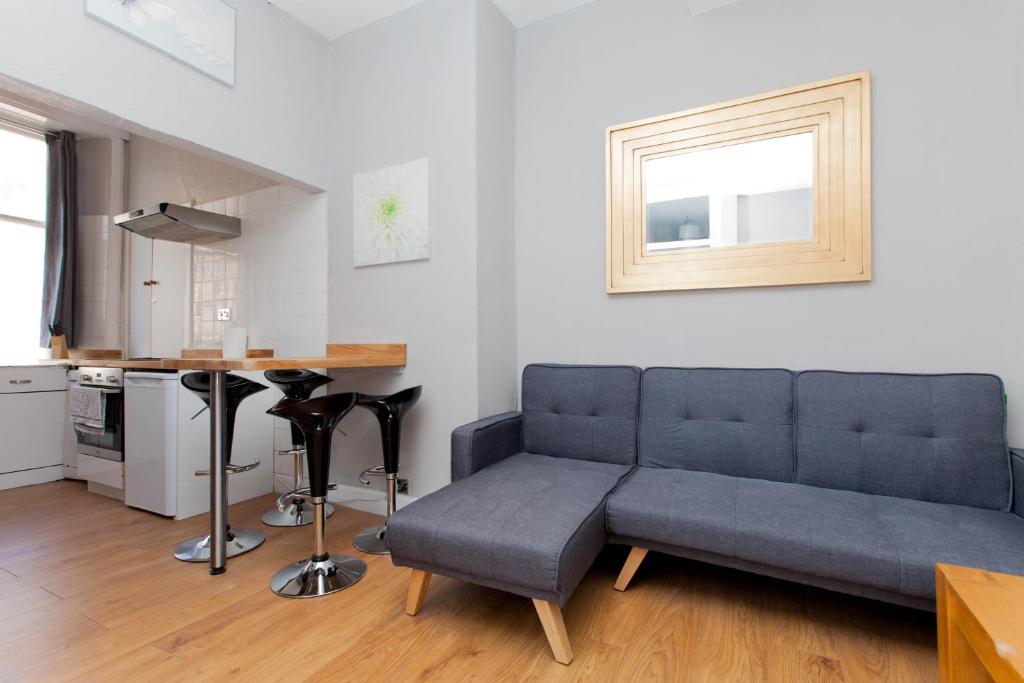 a living room with a couch and a table at Bright & Homely City Centre Apartment near Holyrood in Edinburgh