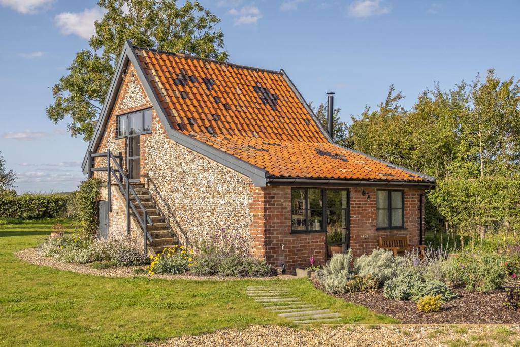 a small brick house with an orange roof at Granary Cottage in Wenhaston