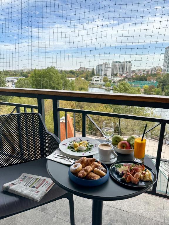 a table with two plates of food on a balcony at Caro Hotel in Bucharest