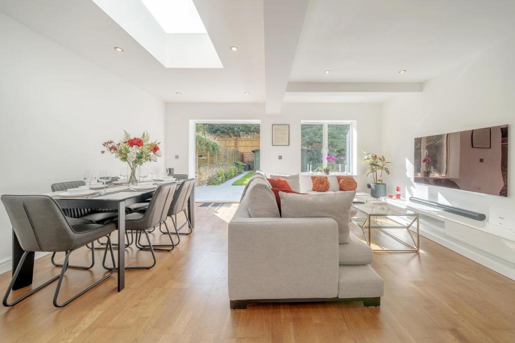 a dining room and living room with a table and chairs at Maida Vale Gem by Little Venice with Stunning Garden in London