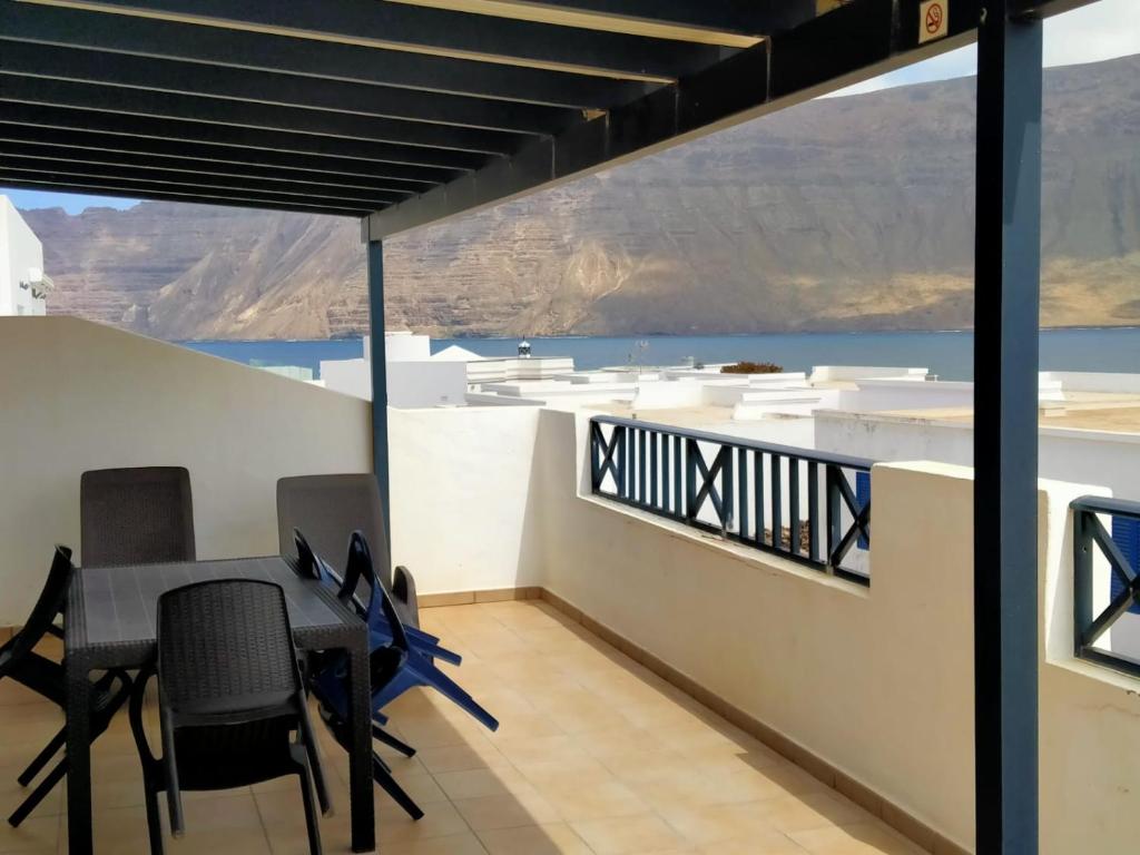 uma sala de jantar com mesa e cadeiras e vista para o oceano em VILLA LA TEGALA em Caleta de Sebo