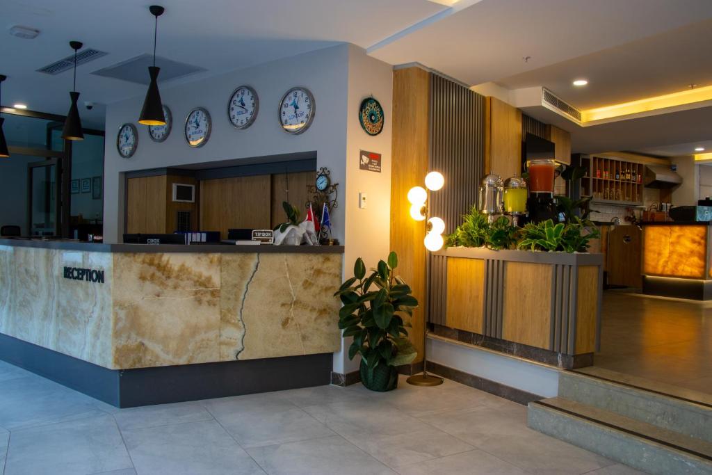 a lobby with a counter with clocks on the wall at Peramis Hotel & Spa in Antalya