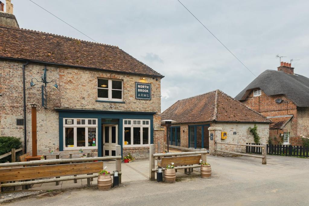 een gebouw met twee banken ervoor bij The Barrel Room at The Northbrook Arms in Winchester