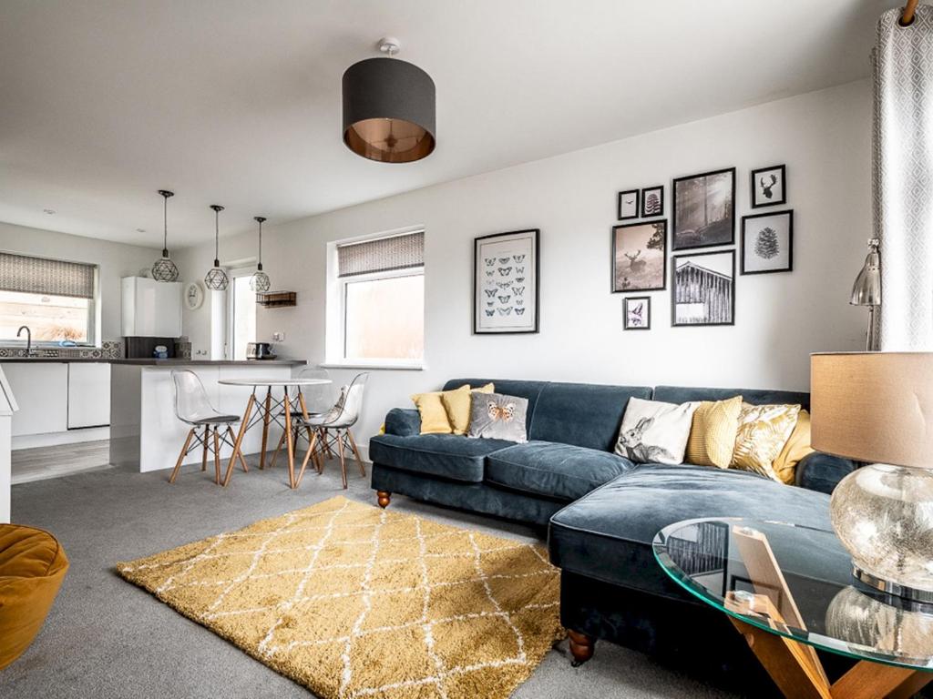 un soggiorno con divano blu e tavolo di Modern and comfortable home near the river with parking a Exeter