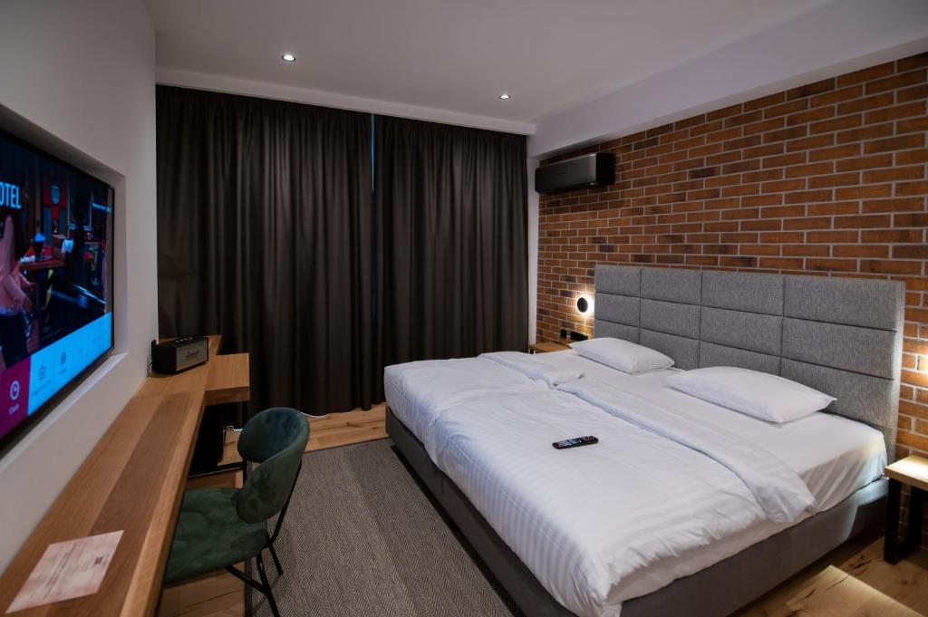 a bedroom with a large bed and a brick wall at Caro Hotel in Bucharest