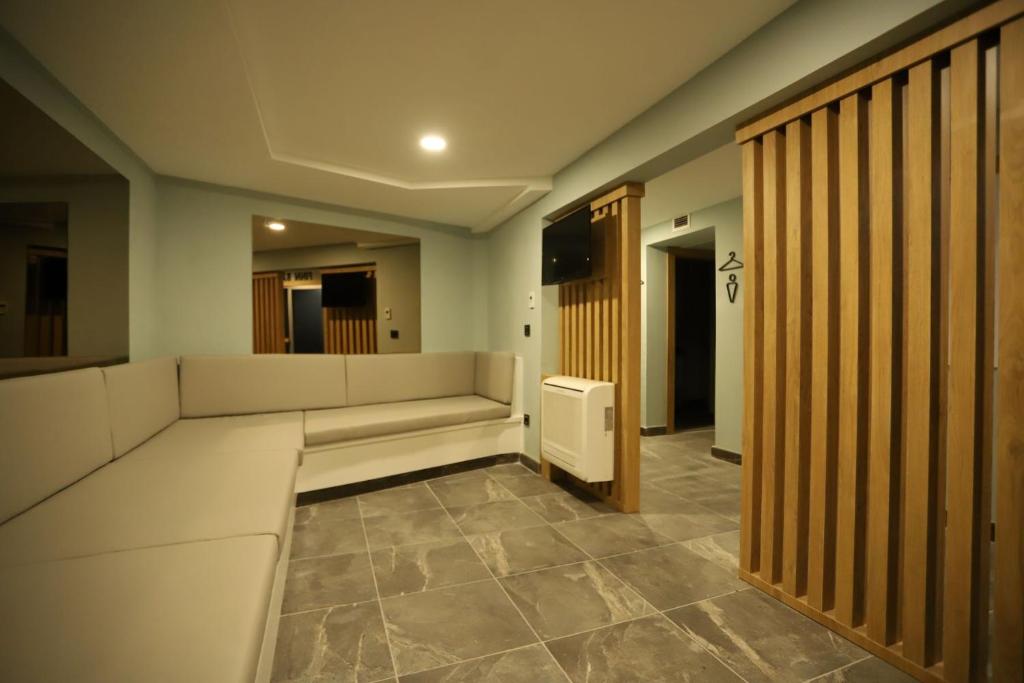 a waiting room with white couches and a television at Peramis Hotel & Spa in Antalya