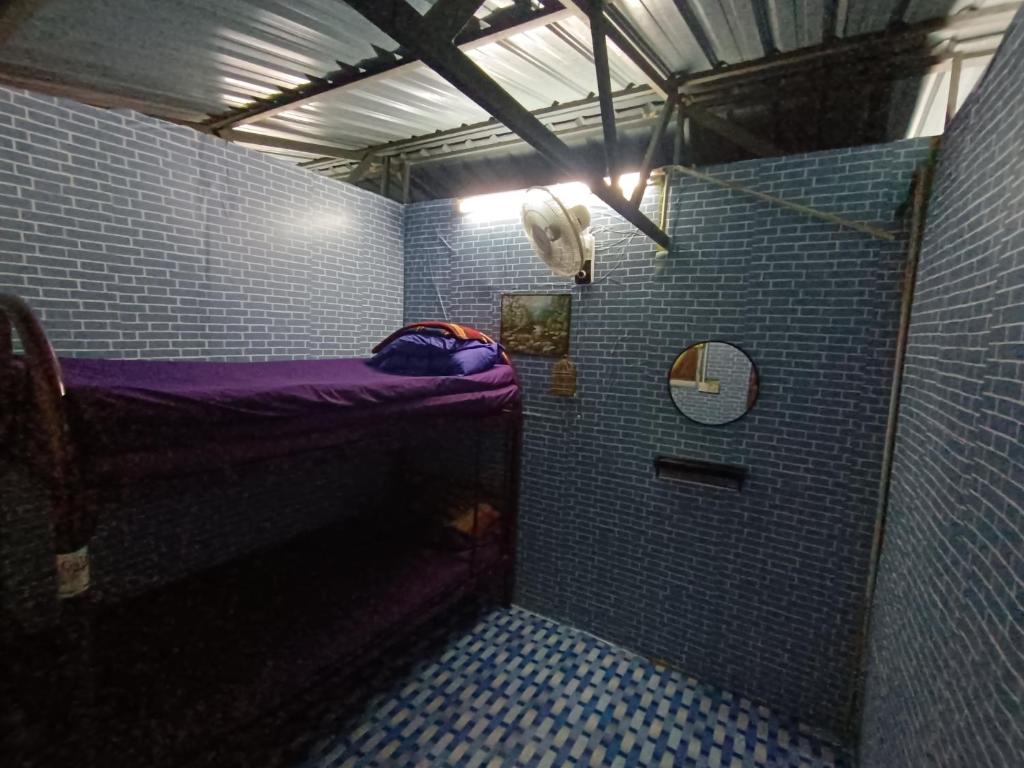 una pequeña ducha con una cama morada en una habitación en Houseboat Sinar Belum, en Gerik