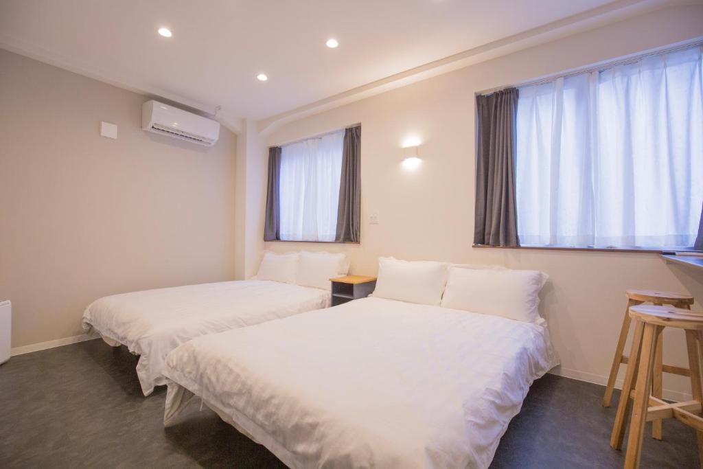 duas camas num quarto com duas janelas em Cozy 4-Guest Stay in Heart of Asakusabashi, Tokyo DSoY em Tóquio