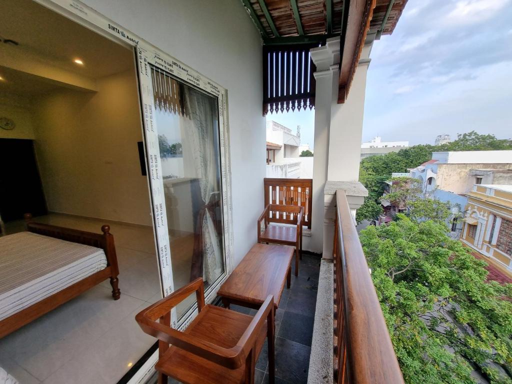 d'un balcon avec des bancs, un lit et une fenêtre. dans l'établissement RVS Chalet, à Pondichéry