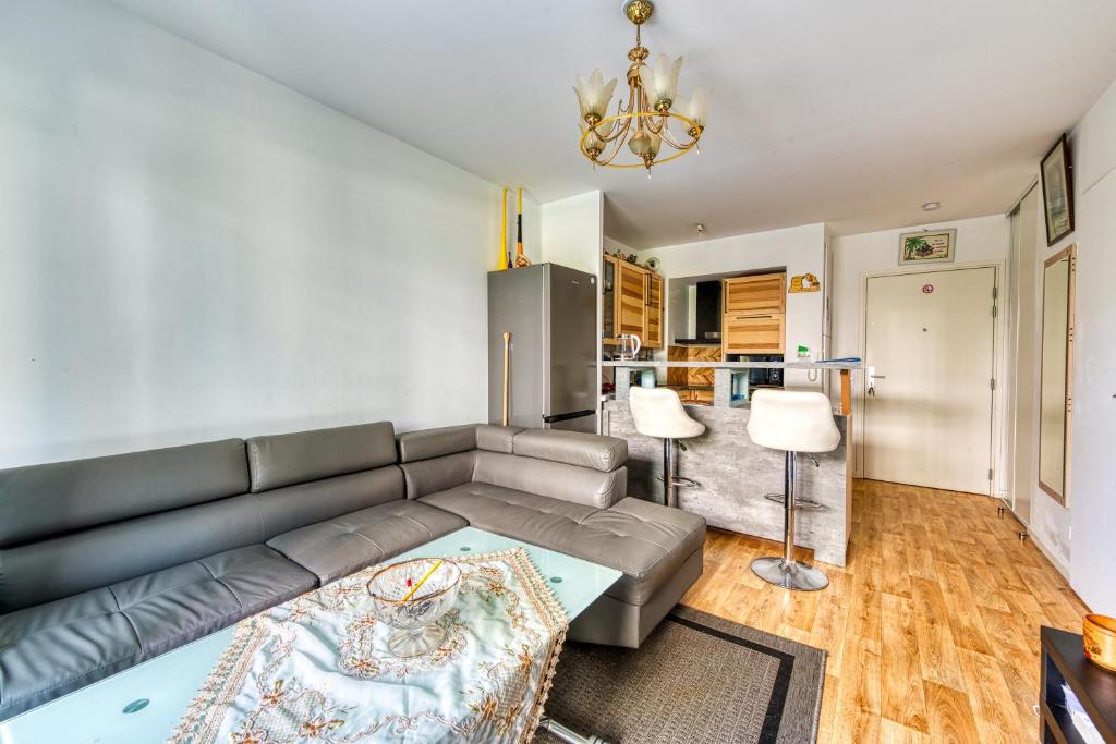 uma sala de estar com um sofá e uma mesa em Le Mendès France - Région parisienne em Vauréal
