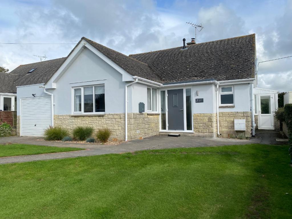 a white house with a lawn in front of it at Shipton Hill View in Loders