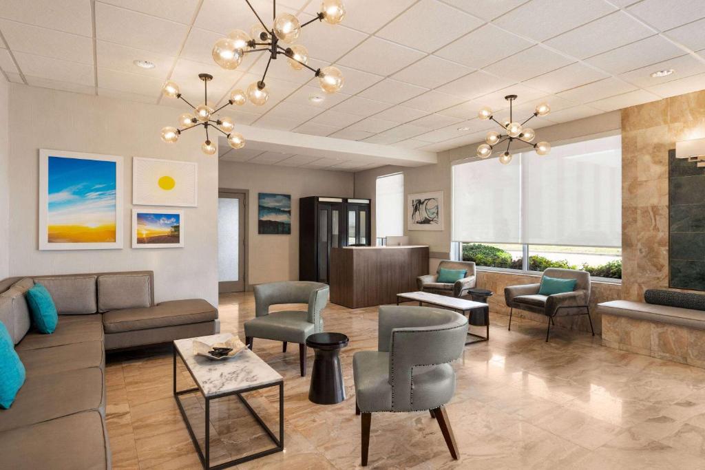 a waiting room with a couch and chairs and a table at Days Inn by Wyndham Miami Airport North in Miami