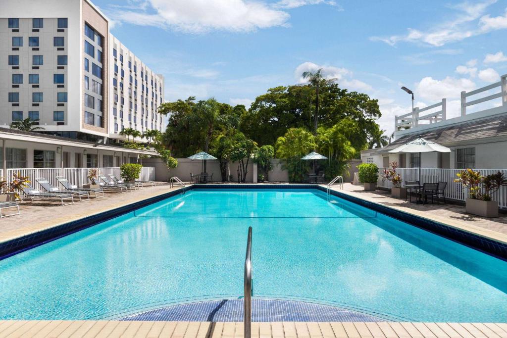 a swimming pool at a hotel with a building at Days Inn by Wyndham Miami Airport North in Miami