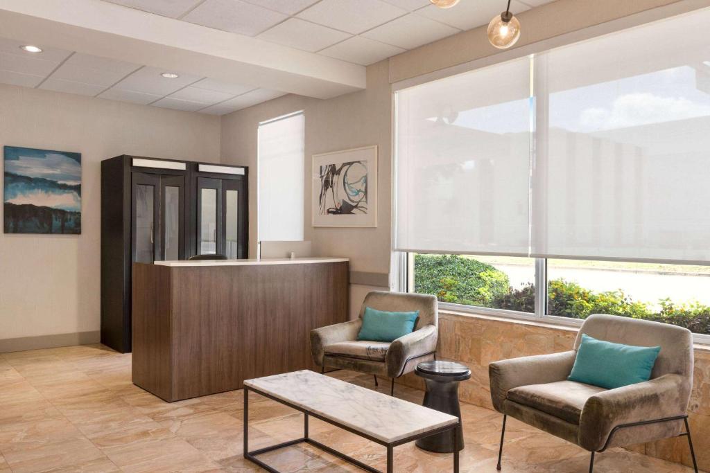 a waiting room with two chairs and a counter at Days Inn by Wyndham Miami Airport North in Miami