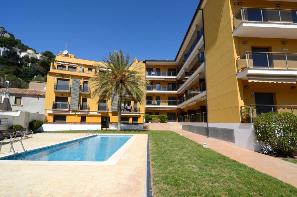 un complexe d'appartements avec une piscine en face d'un bâtiment dans l'établissement PINIMAR B 3-4, à L'Estartit