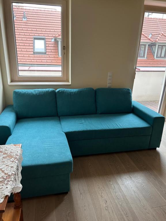 een blauwe bank in een woonkamer met een raam bij Apartment Vienna 56 in Wenen