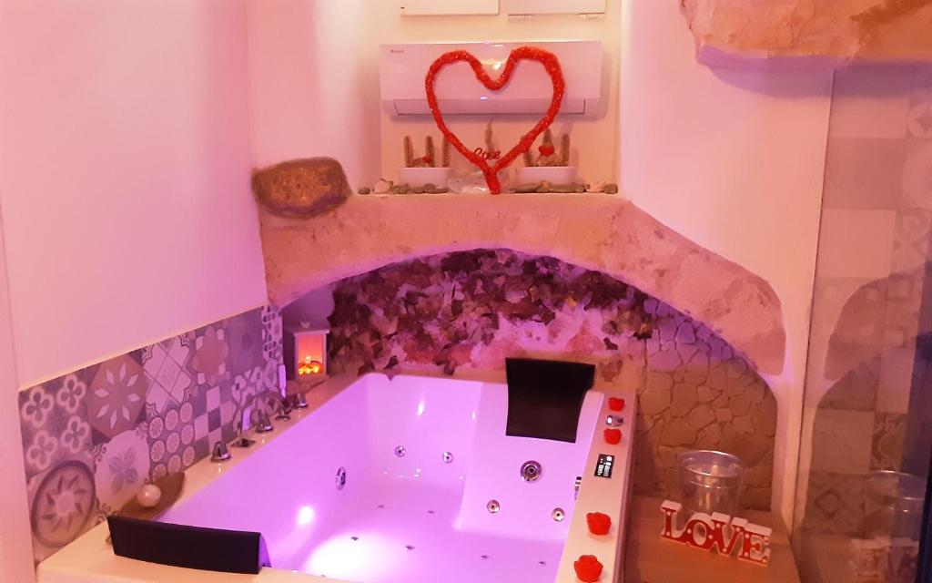 a bathroom with a tub with a heart on the wall at C'era una volta Relax in Altamura